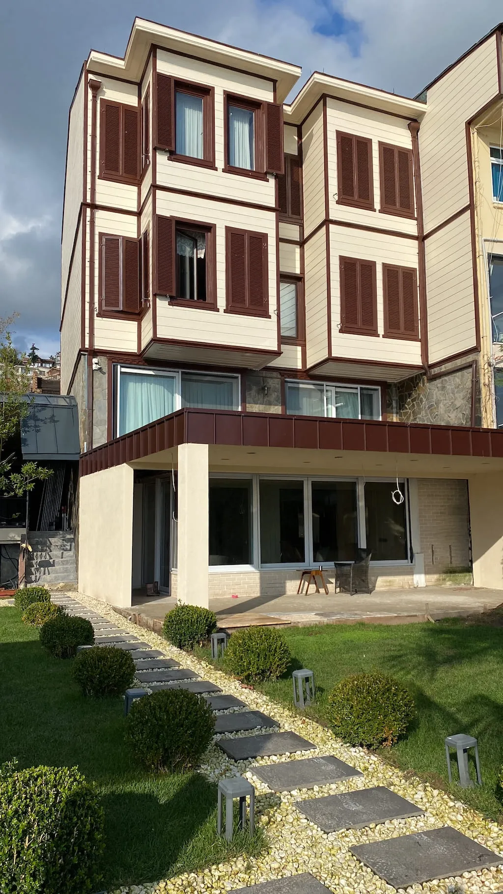 Ahşap görünümlü dış cephe kaplaması ve panjurları yenilenen üç katlı villanın tamamlanmış cephesi