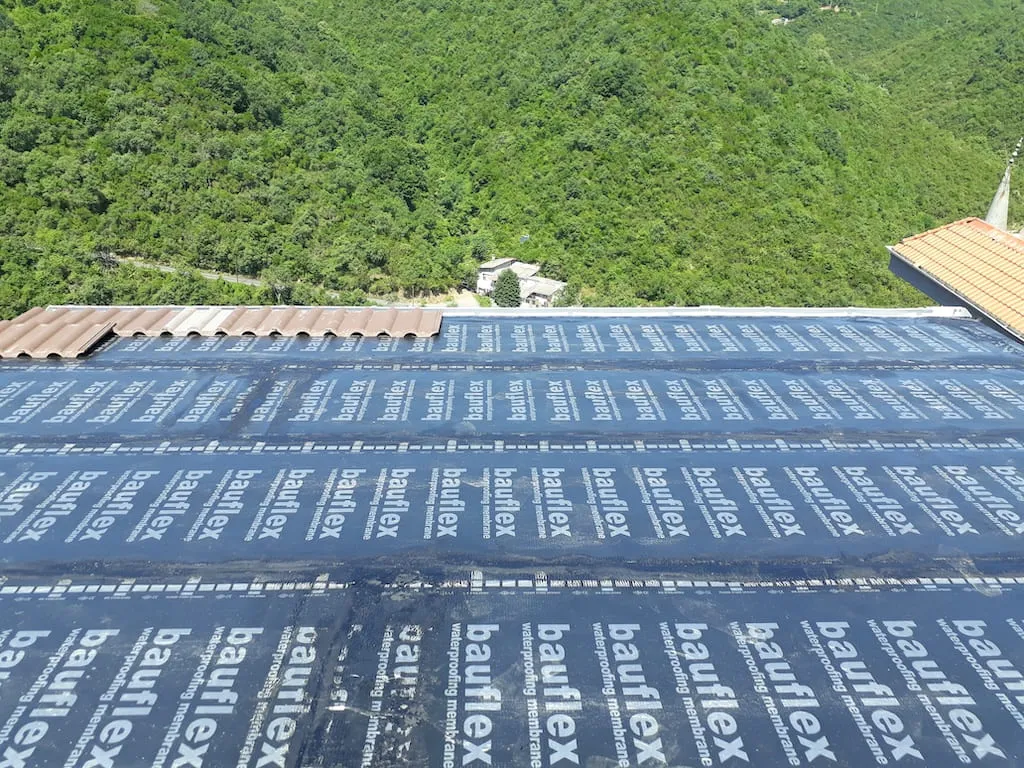 Membranla kaplanan geniş çatıda metal kiremit döşeme aşaması, çatı aktarma uygulaması