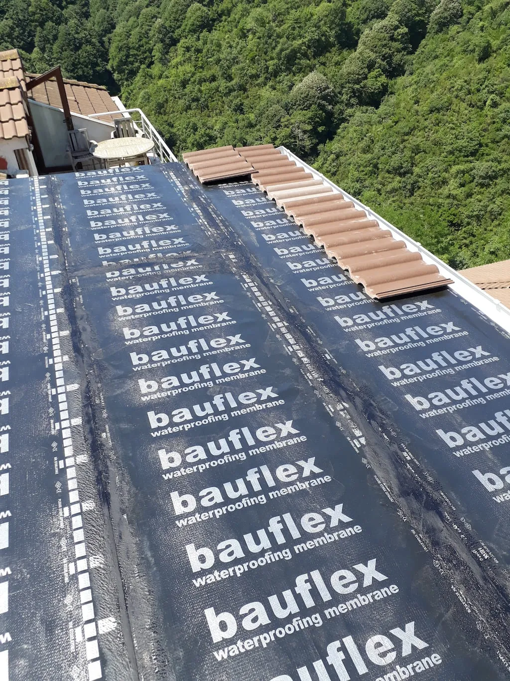 Su yalıtım membranı serilmiş eğimli çatıya kahverengi metal kiremit döşenmesi