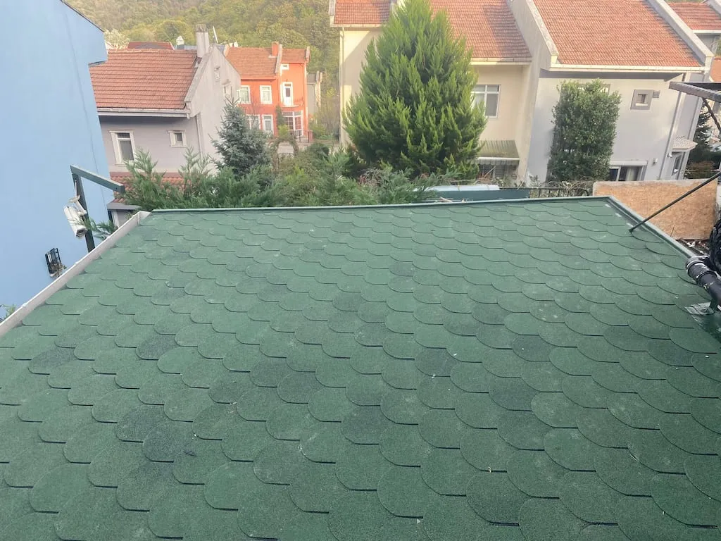 Sarıyer'de yenilenen eğimli çatıda yeni serilmiş yeşil oval kesim shingle kaplama