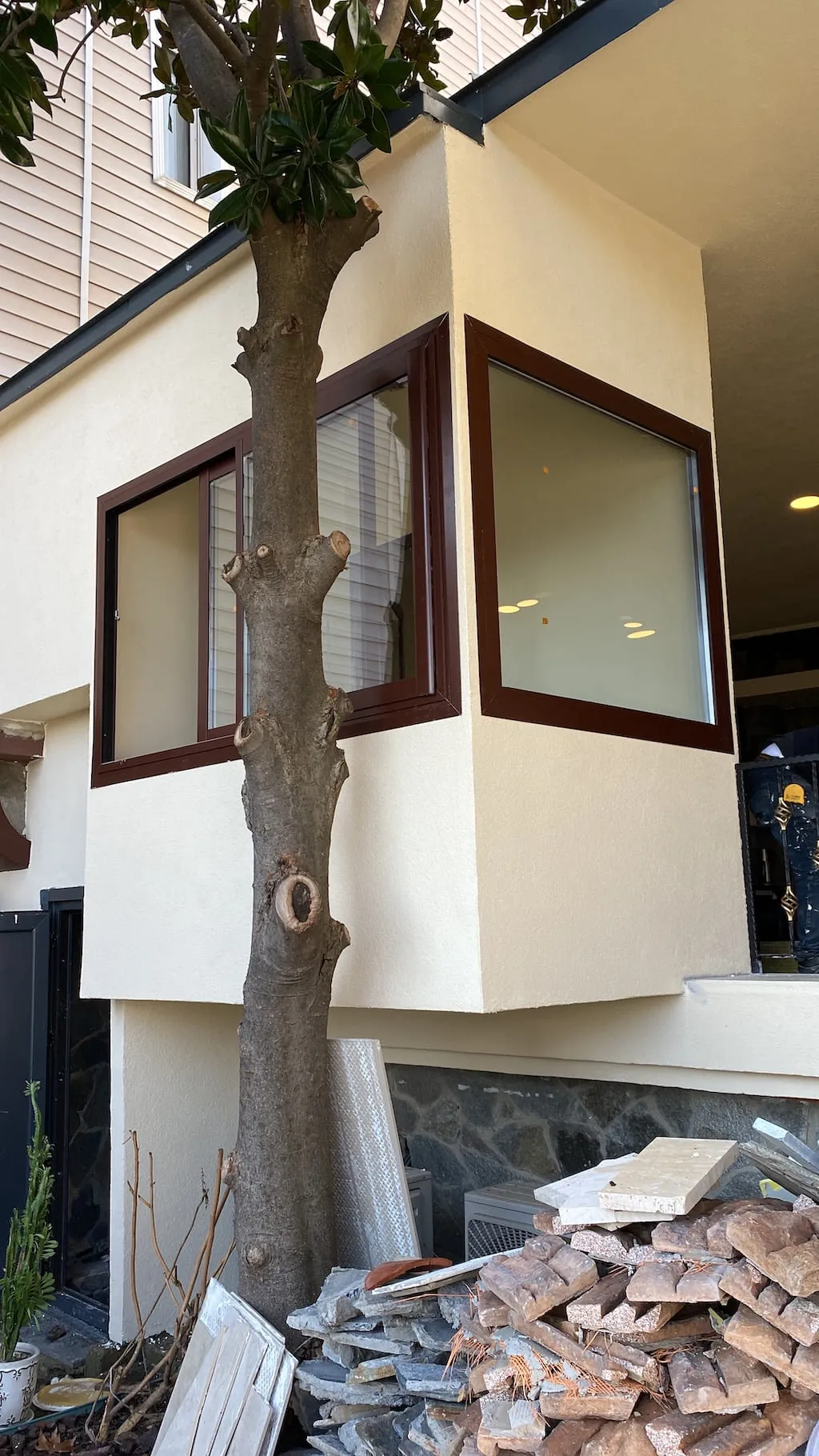 Mantolama sonrası krem dekoratif sıva uygulanan cephe ve bordo doğramalı köşe penceresi